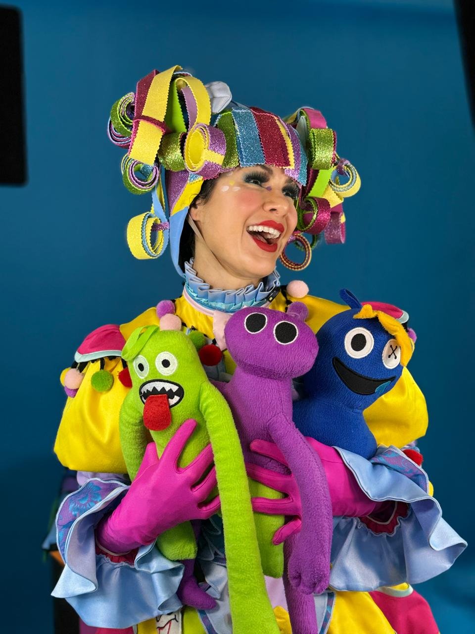Zuni, personagem de Histórias de Zuni, sorrindo com bonecos coloridos